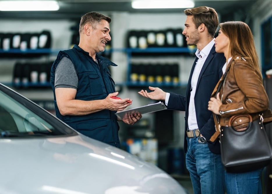 A tire saleman talking to a couple