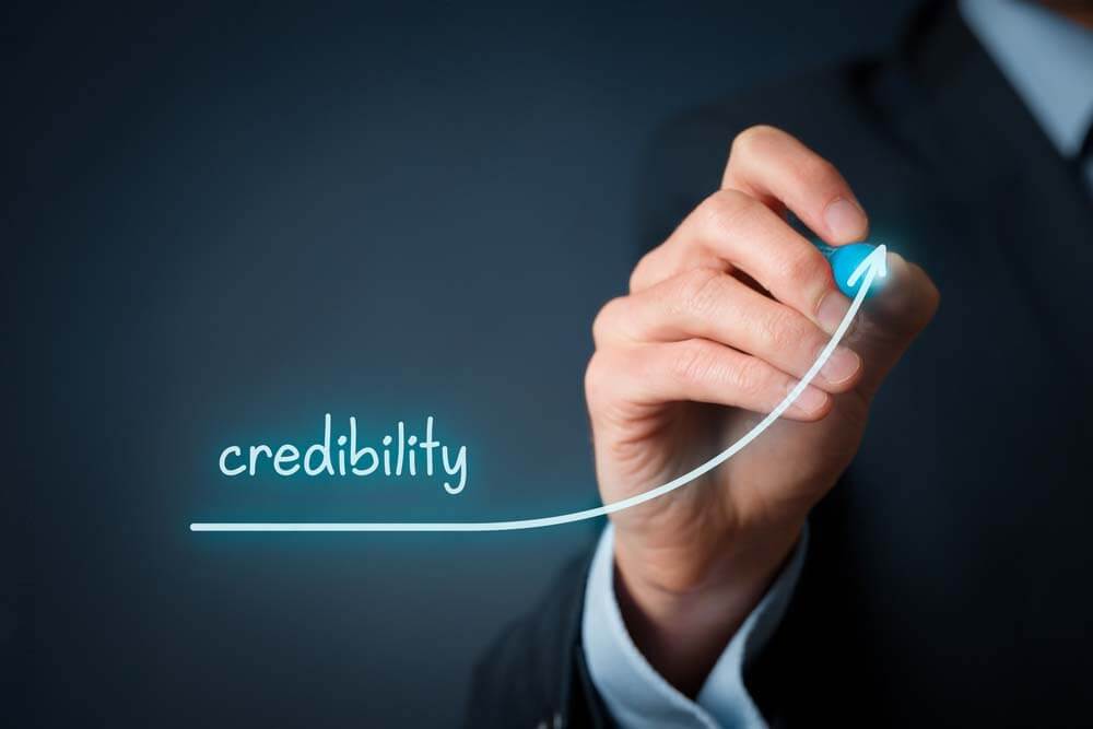 businessman with a graphy that slopes upwards and says credibility