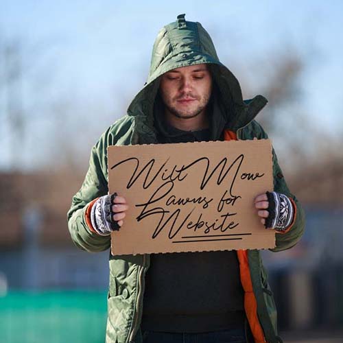 homeless business owner with a sign that says 'Will Mow Lawn For Website'